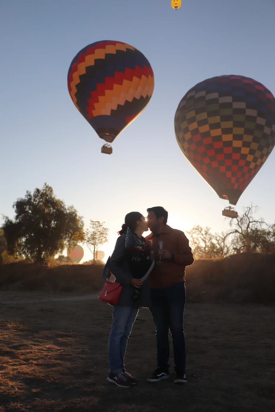 Una pareja se abraza entre globos al amanecer